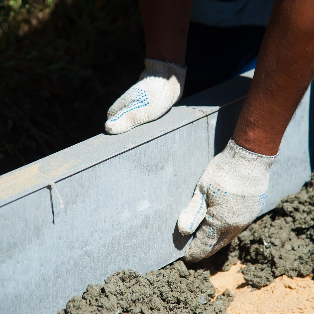 Adult constructing edging with cement and tools
