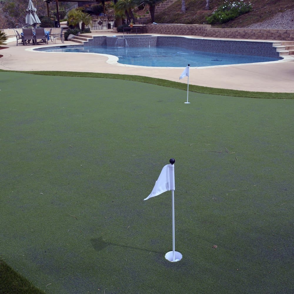 Backyard putting green beside a pool