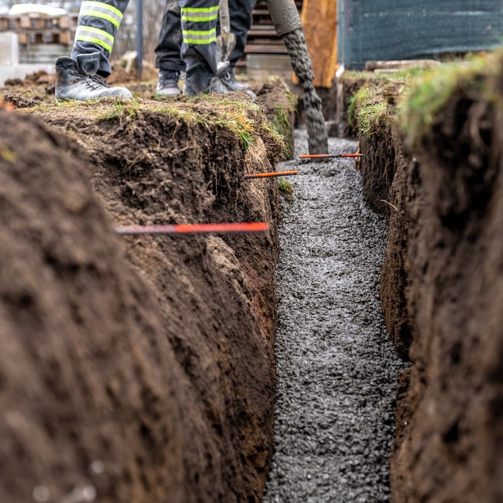 Construction crew pours concrete for foundation