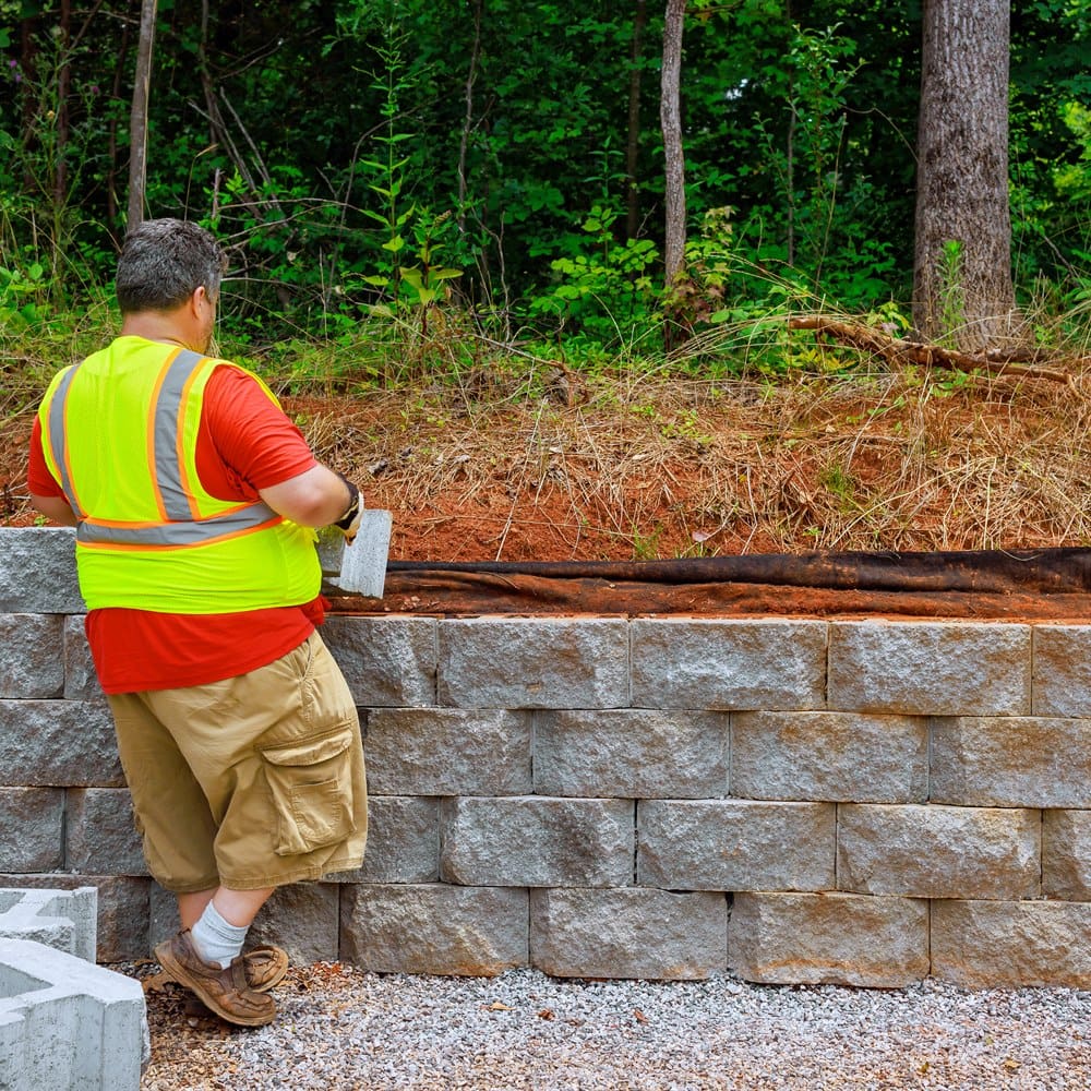 Construction worker installing a stone retaining