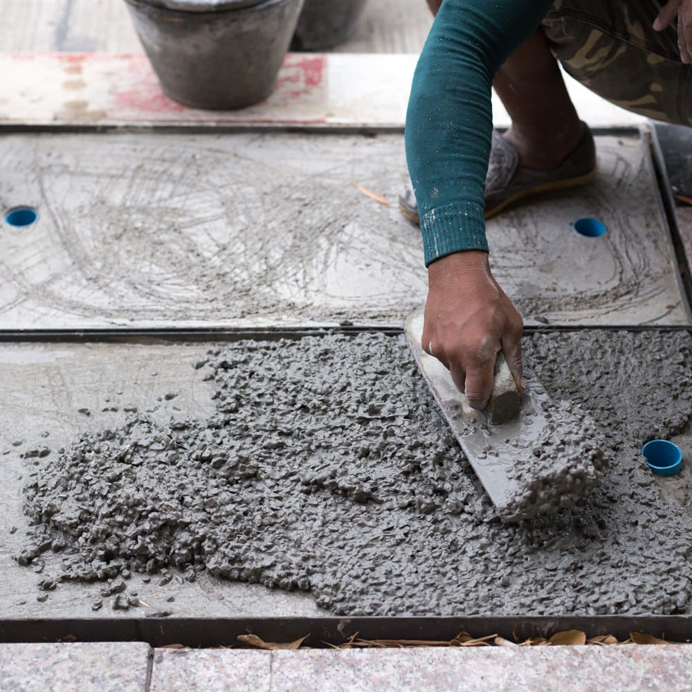 Construction worker smoothing concrete with trowel