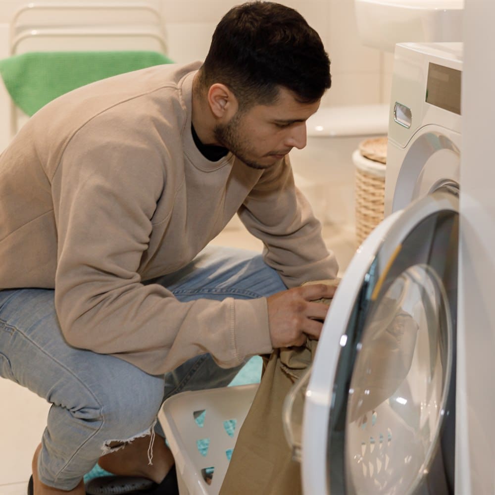 man-doing-laundry-in-a-bathroom Man doing laundry in a bathroom