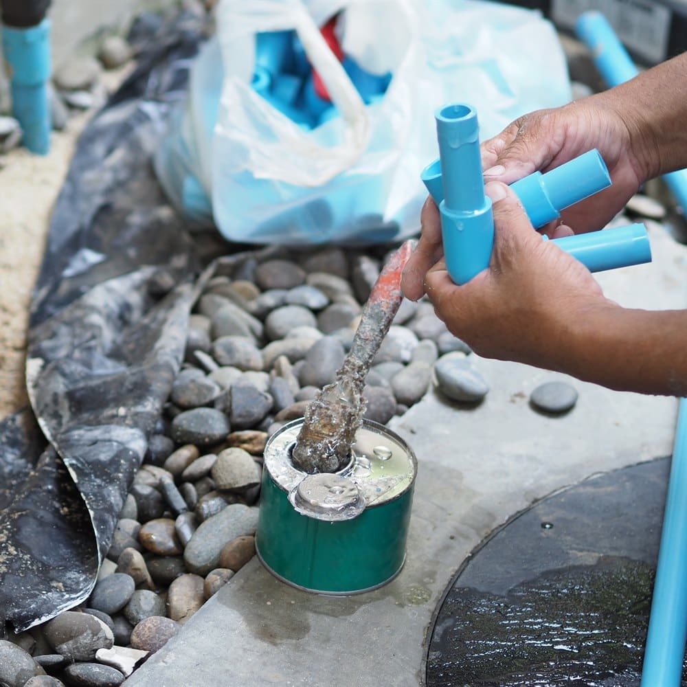 Plumber assembling plastic pipes for repairing water