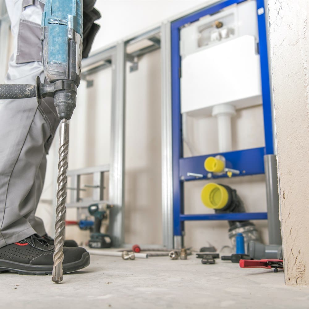 Worker using a drill in a construction setting
